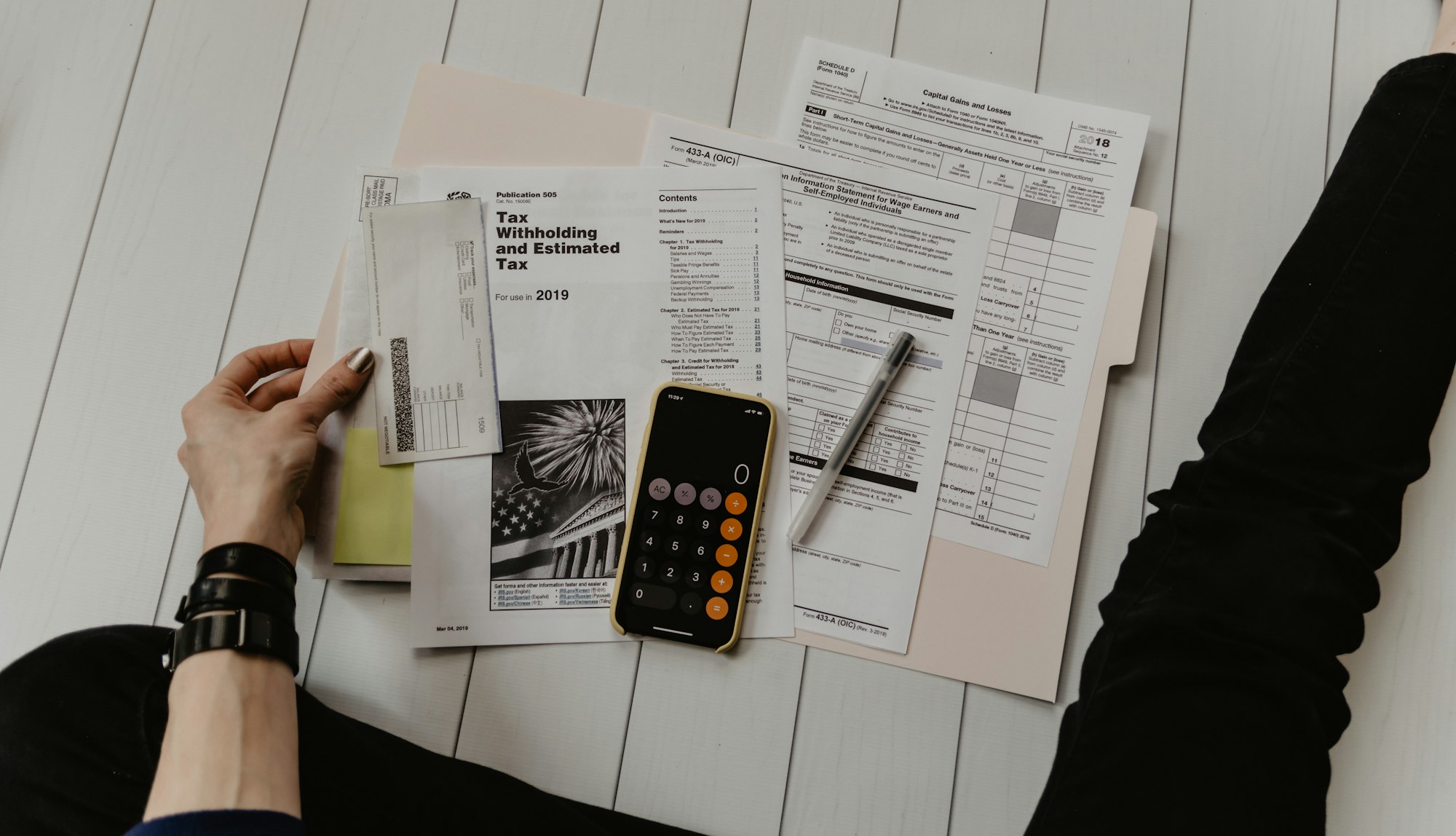 Statements, a calculator, and a notebook spread across a table