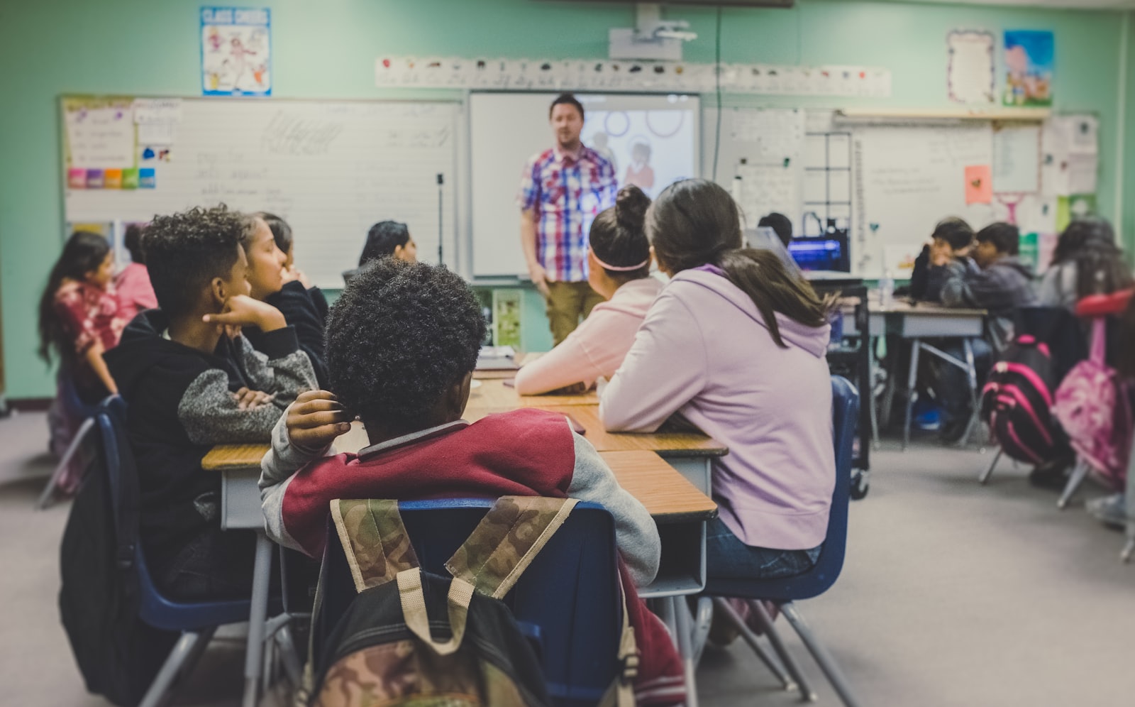 Adults seated at desks in a bright classroom during a training workshop